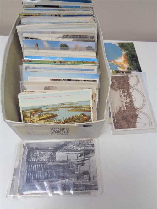 A box of early twentieth century and later colour and black and white postcards