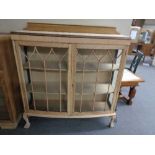 An early twentieth century stripped double door cabinet on claw & ball feet