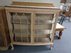 An early twentieth century stripped double door cabinet on claw & ball feet