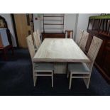 A contemporary dining table with travertine inset panel and set of six high backed chairs in washed