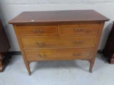 An Edwardian inlaid mahogany four drawer chest. Height 86 cm x length 108 cm x width 50 cm.