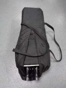 A red kite travel cot in bag