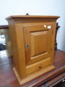 An early twentieth century wall cabinet fitted with a drawer