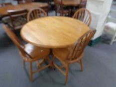 A circular pedestal dining table together with four chairs, diameter 107 cm, height 75 cm.