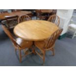 A circular pedestal dining table together with four chairs, diameter 107 cm, height 75 cm.