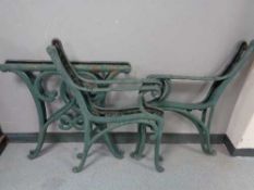 Two pairs of cast iron bench ends together with a pair of cast iron table ends