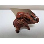 A carved fruitwood netsuke in the form of a rat riding an elephant