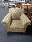 A late Victorian armchair upholstered in green brocade fabric on bun feet