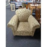 A late Victorian armchair upholstered in green brocade fabric on bun feet