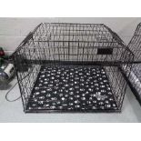 A folding black metal dog cage, height 67 cm, width 94 cm, depth 78 cm.