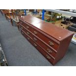 A mahogany effect three drawer chest together with a pair of three drawer bedside chests