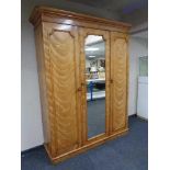 A Victorian ash triple door wardrobe with central mirrored panel door