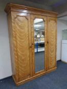 A Victorian ash triple door wardrobe with central mirrored panel door