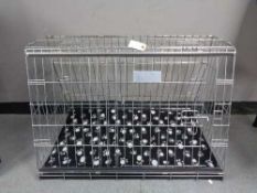 A folding black metal dog cage, height 67 cm, width 86 cm, depth 56 cm.