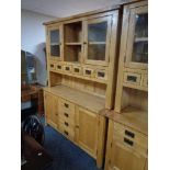 A contemporary oak kitchen dresser fitted with four drawers with cupboards and six further drawers.