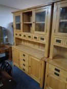 A contemporary oak kitchen dresser fitted with four drawers with cupboards and six further drawers.