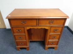 A Georgian style knee hole writing desk fitted with cupboard and eight drawers