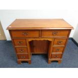 A Georgian style knee hole writing desk fitted with cupboard and eight drawers