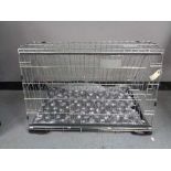 A folding black metal dog cage, height 52 cm, width 82 cm, depth 50 cm.