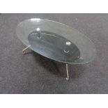 A contemporary oval glass topped coffee table