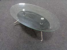 A contemporary oval glass topped coffee table