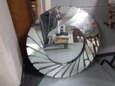 A contemporary circular all glass wall mirror