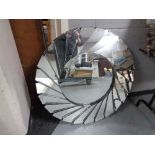 A contemporary circular all glass wall mirror