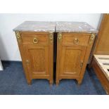 A pair of antique oak French bedside cabinets with marble tops and gilt metal mounts.