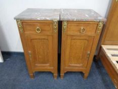 A pair of antique oak French bedside cabinets with marble tops and gilt metal mounts.