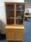 A Schreiber teak effect double door bookcase fitted with double door cabinet