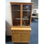 A Schreiber teak effect double door bookcase fitted with double door cabinet