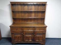 A heavy oak kitchen dresser fitted with three drawers and carved panel doors 186 cm height,