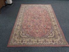 A machined Persian design fringed rug on pink ground