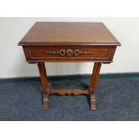 A reproduction mahogany work table with under stretcher and column supports