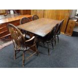 An oak effect refectory dining table together with set of five wheel backed chairs