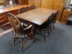 An oak effect refectory dining table together with set of five wheel backed chairs