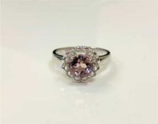 A silver dress ring set with a pale pink stone,