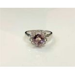 A silver dress ring set with a pale pink stone,