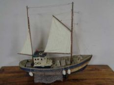 A wooden model of a fishing trawler on wooden stand