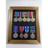 Nine reproduction military medals on ribbons in frame