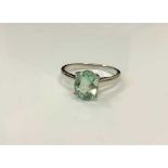 A silver dress ring set with a pale green stone,