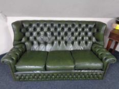 A green buttoned leather wing backed settee