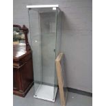 A square all glass display cabinet (no shelves) together with a boxed flat packed Ikea table