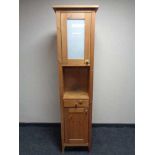 A double door narrow storage cupboard fitted with a drawer