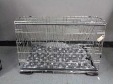 A folding black metal dog cage, height 52 cm, width 82 cm, depth 50 cm.