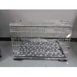 A folding black metal dog cage, height 52 cm, width 82 cm, depth 50 cm.