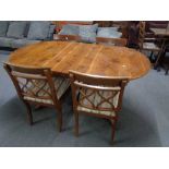 An inlaid yewwood oval dining table together with four chairs
