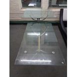 A contemporary glass topped pedestal dining table together with similar coffee table