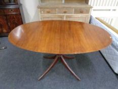 An oval inlaid mahogany pedestal dining table