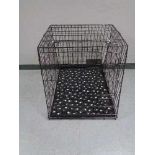 A folding black metal dog cage, height 70 cm, width 68 cm, depth 84 cm.